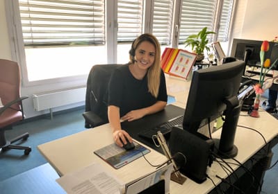 Apprendista con cuffie e microfono alla sua postazione di lavoro Apprendista con cuffie e microfono alla sua postazione di lavoro